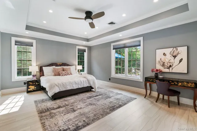 a bed sitting in a spacious bedroom next to a window