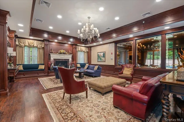 a living room with furniture a chandelier and a fireplace