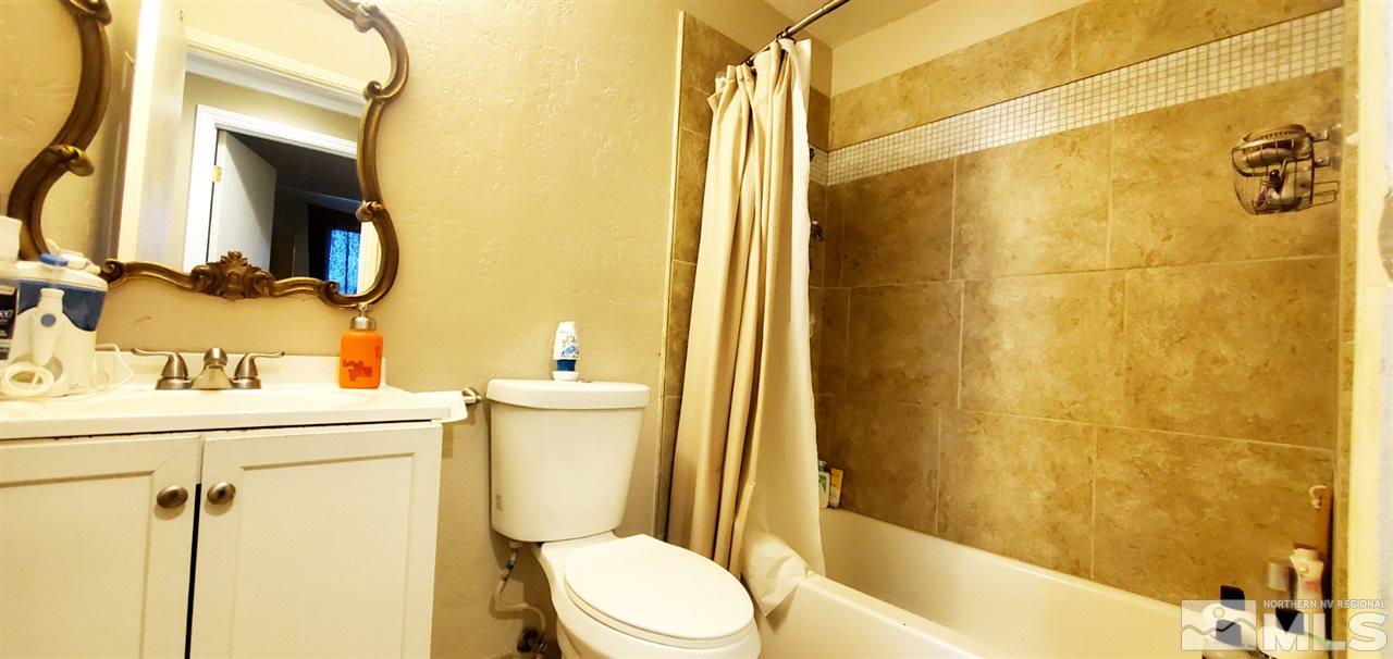 14095 Kernite Street Reno, NV 89506 - Photo 9 of 13 a bathroom with a sink a toilet and shower