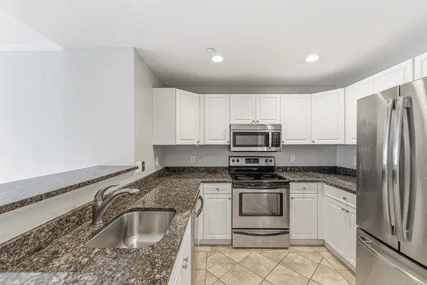 a view of kitchen with refrigerator sink and cabinets