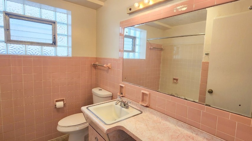 2552 West Rascher Avenue, Unit G Chicago, IL 60625 - Photo 6 of 8 a bathroom with a sink vanity granite toilet and a mirror