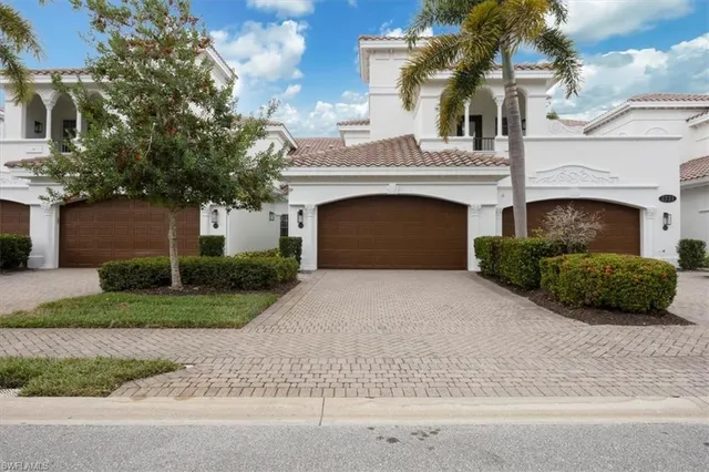 a front view of a house with a garden and garage