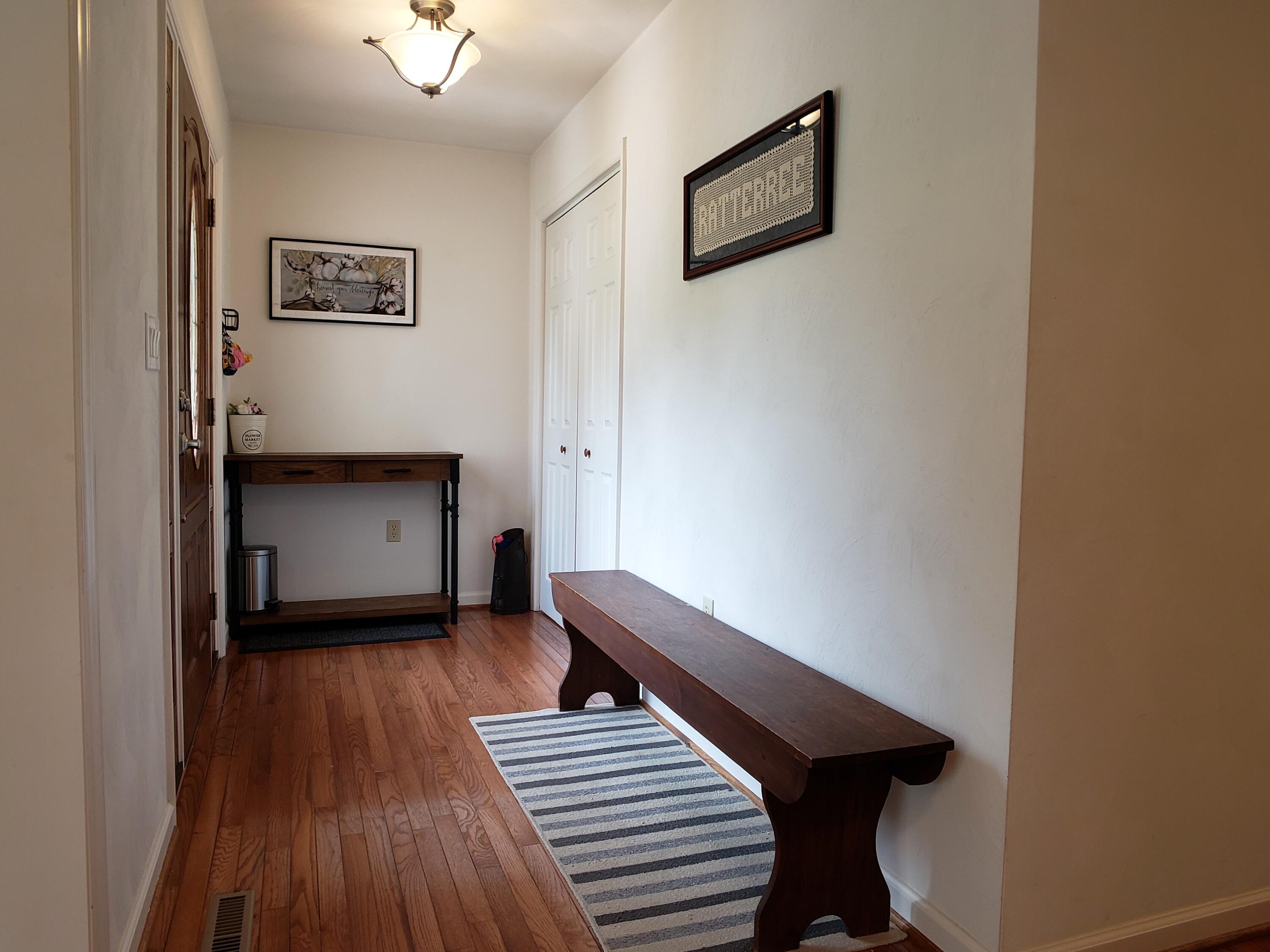 1259 Windy Hill Road Goodview, VA 24095 - Photo 3 of 36 a view of a hallway with wooden floor and staircase