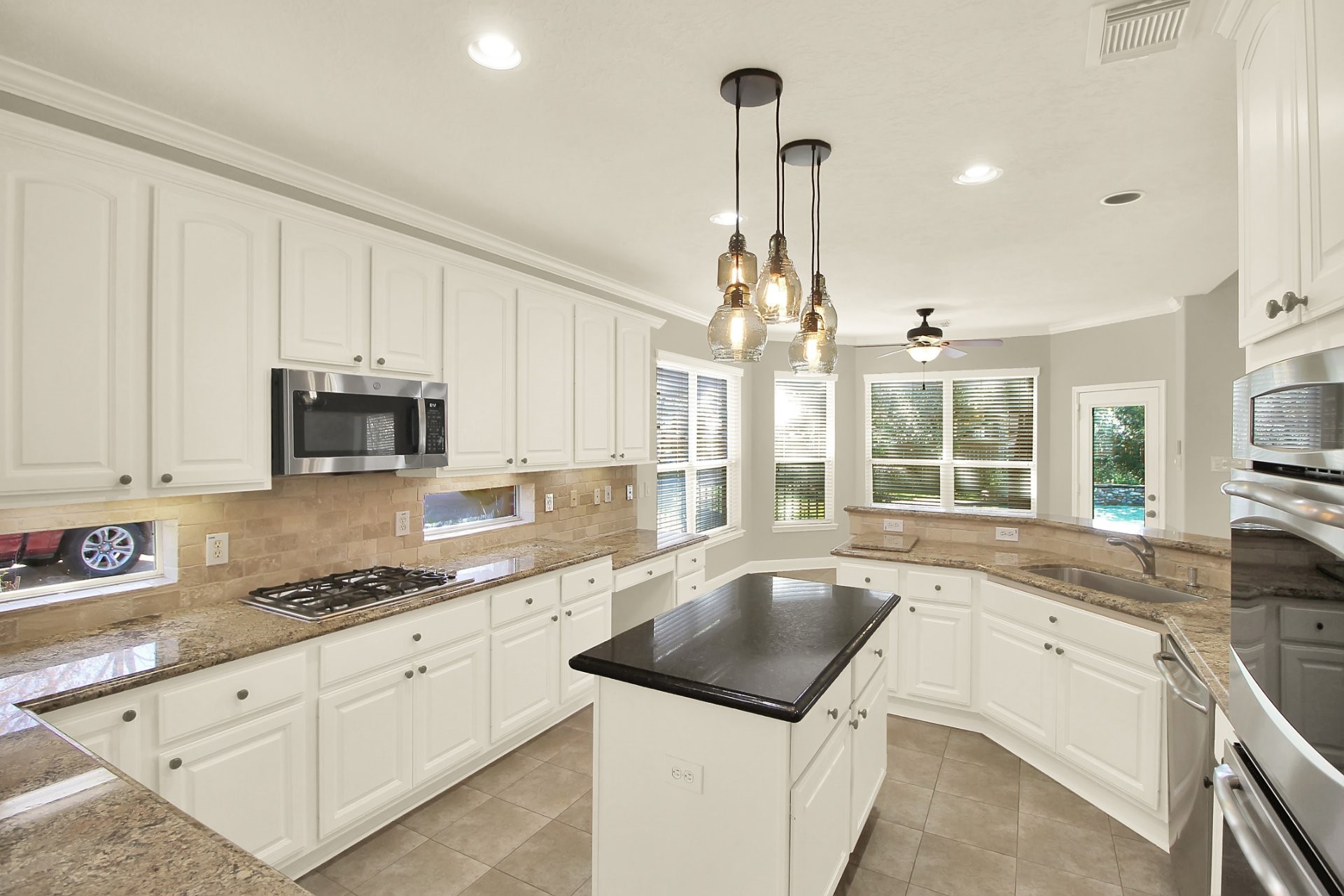 601 Forest Bend Lane Friendswood, TX 77546 - Photo 4 of 27 a kitchen with granite countertop a sink and white cabinets