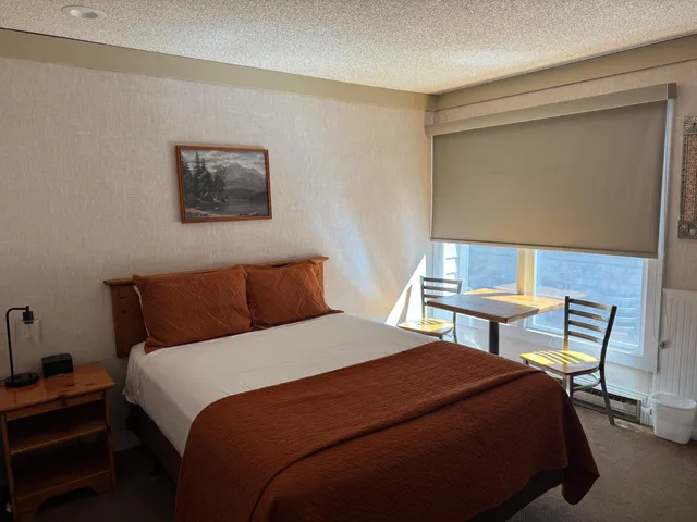 a bedroom with a bed a table and chair