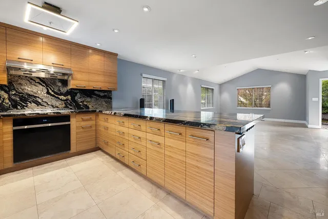 a large kitchen with stainless steel appliances granite countertop a stove sink and cabinets