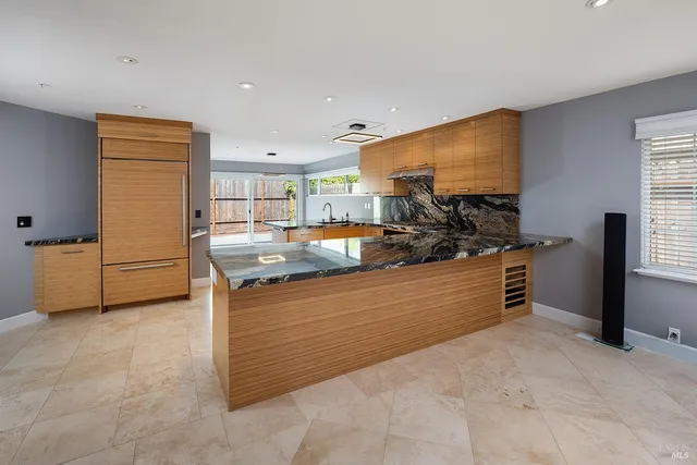 a kitchen with stainless steel appliances granite countertop a stove and a refrigerator