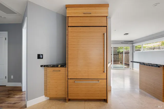 a view of a kitchen with refrigerator and wooden floor