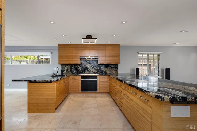 a large kitchen with stainless steel appliances granite countertop a stove and a sink