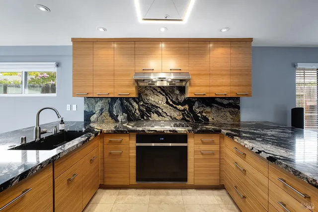 a kitchen with stainless steel appliances granite countertop a sink and cabinets