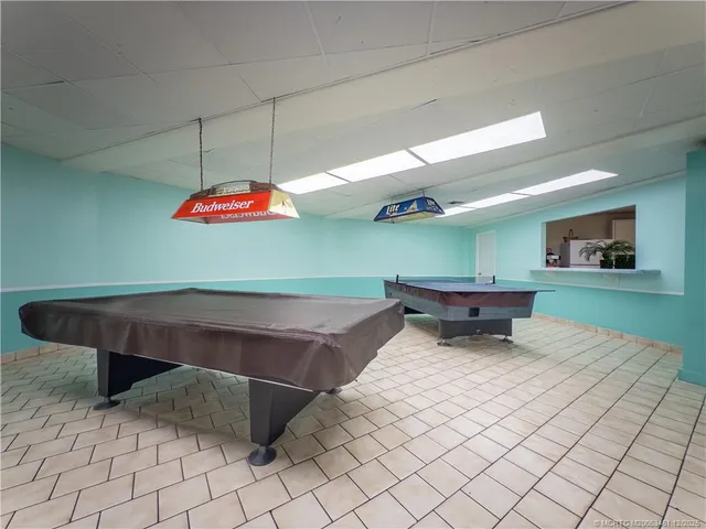 a room with pool table and windows