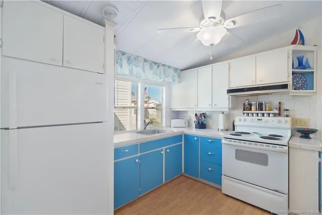 a kitchen with a white cabinets sink and white appliances