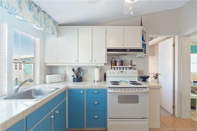 a kitchen with stainless steel appliances a sink stove and cabinets