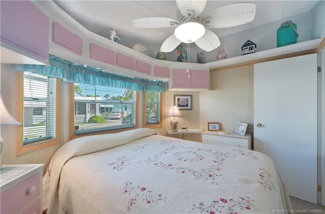 a bedroom with a bed chandelier and a window