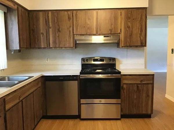a kitchen with granite countertop wood cabinets and stainless steel appliances