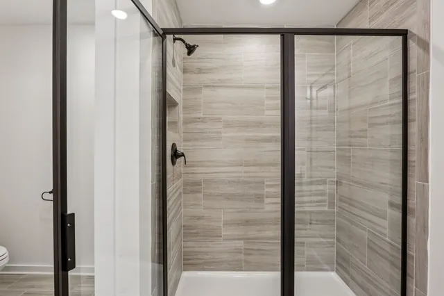 a white toilet sitting next to a shower