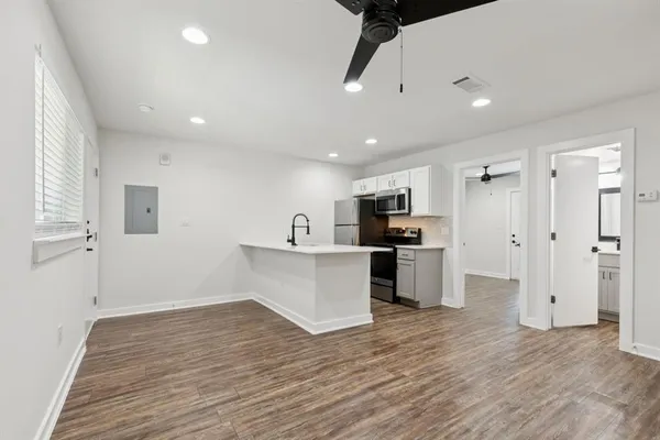 a view of kitchen with stainless steel appliances refrigerator stove microwave and cabinets