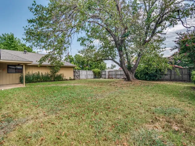 a view of a house with yard and a tree