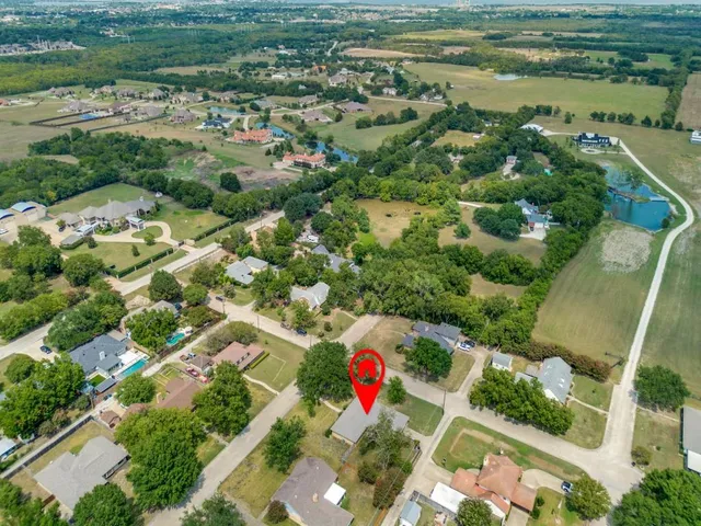 an aerial view of residential houses with outdoor space and trees