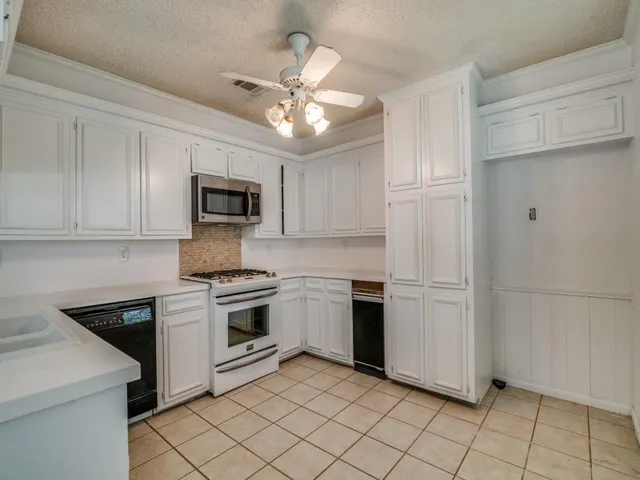 a kitchen with cabinets stainless steel appliances and a counter space