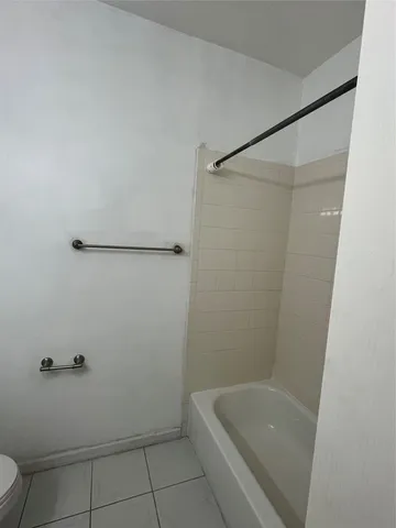 a bathroom with a granite countertop sink a toilet and bathtub