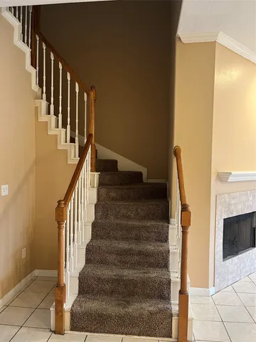a view of staircase with lots of frames on wall and a painting