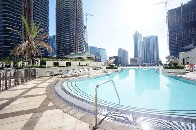 a view of a white building with swimming pool in front of it