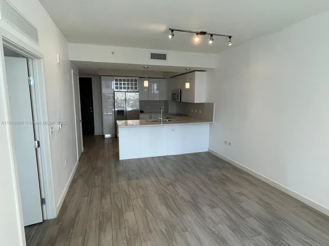 a view of a kitchen with wooden floor and a sink