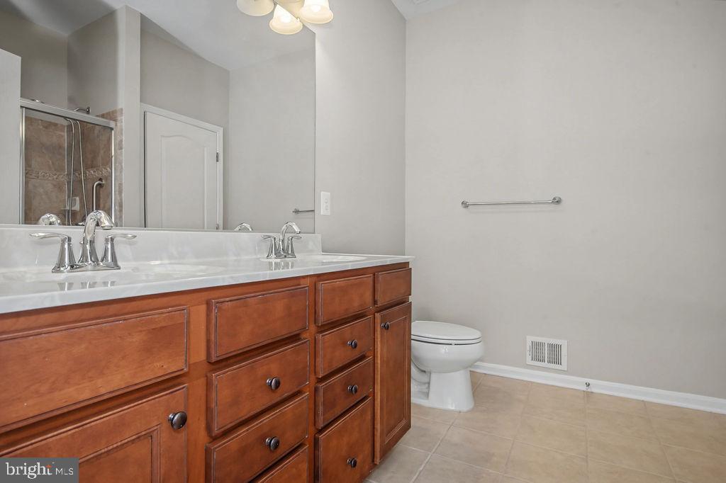 137 Silver Maple Road Middletown, DE 19709 - Photo 14 of 25 a bathroom with a double vanity sink and a toilet