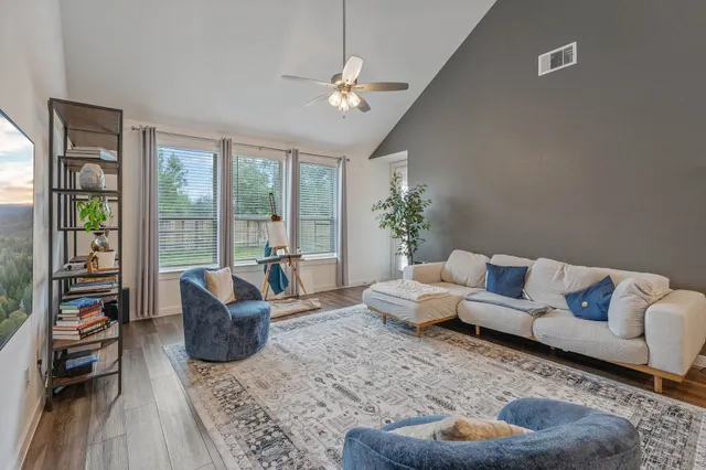 a living room with furniture and a large window with garden view