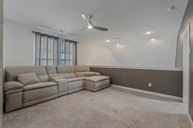 a living room with furniture and a ceiling fan