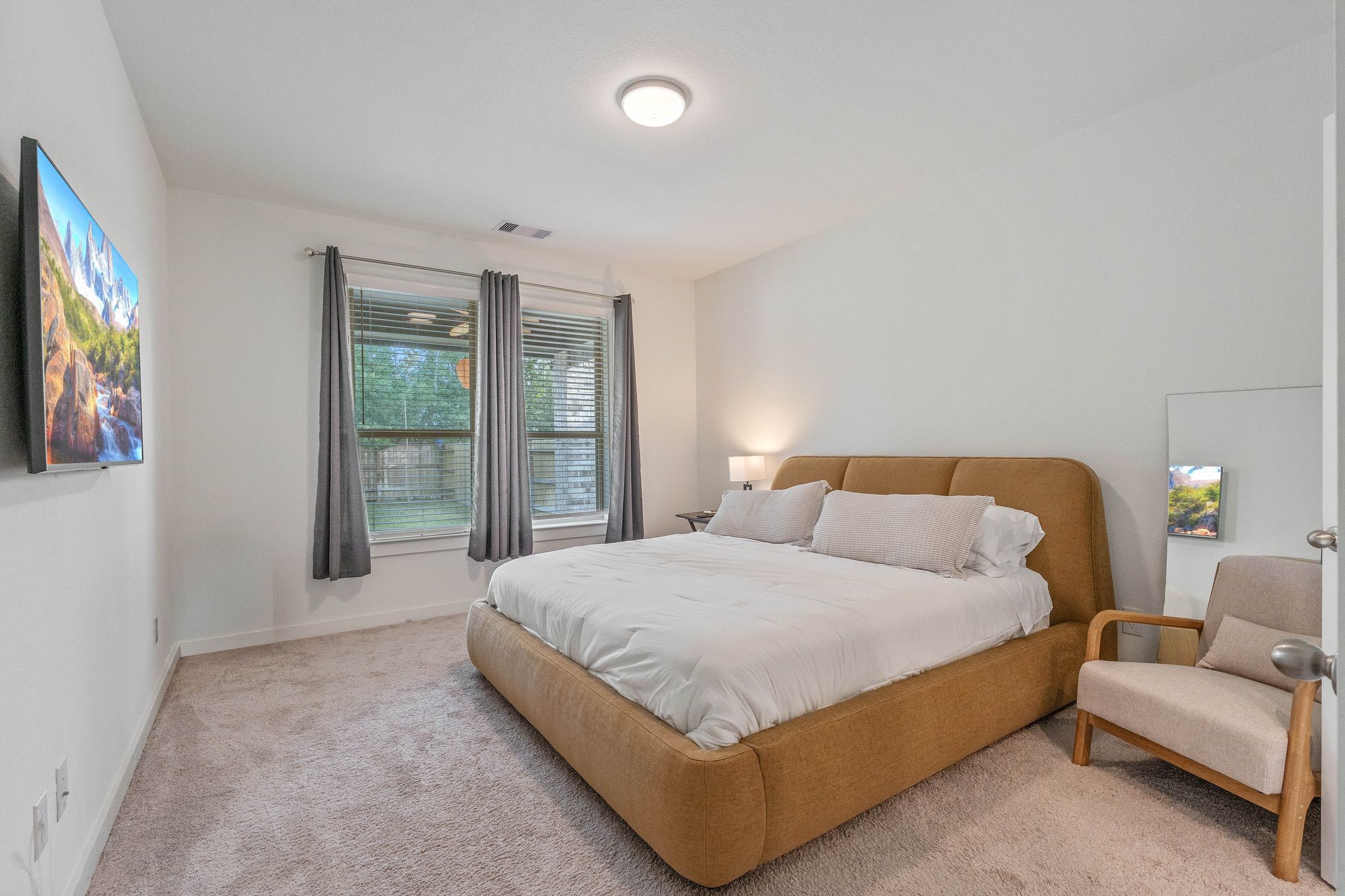 509 Timber Voyage Court Conroe, TX 77304 - Photo 21 of 36 a bedroom with a large bed and a flat tv screen on dresser