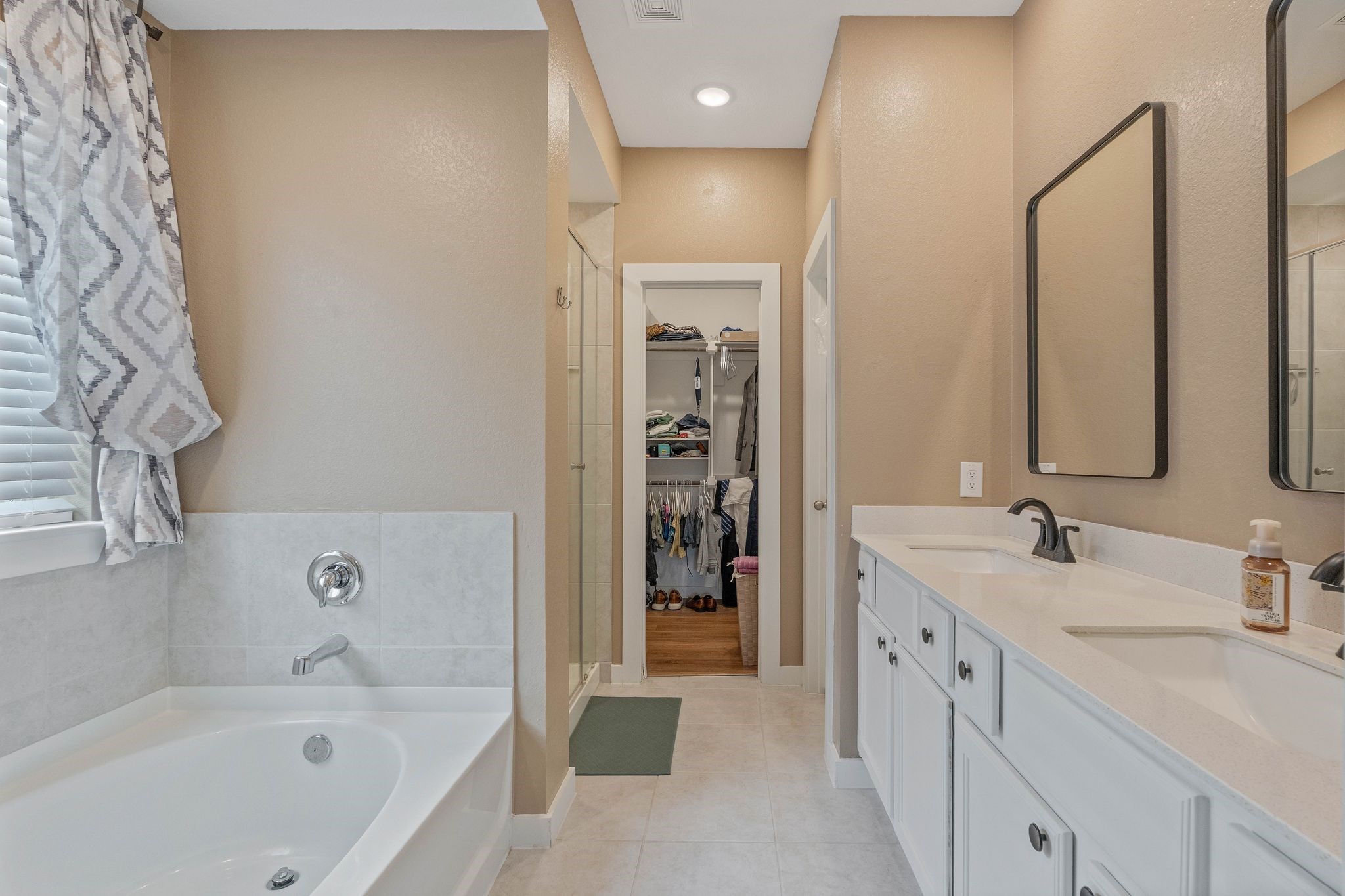 509 Timber Voyage Court Conroe, TX 77304 - Photo 22 of 36 a bathroom with a bathtub a double vanity sink and mirror