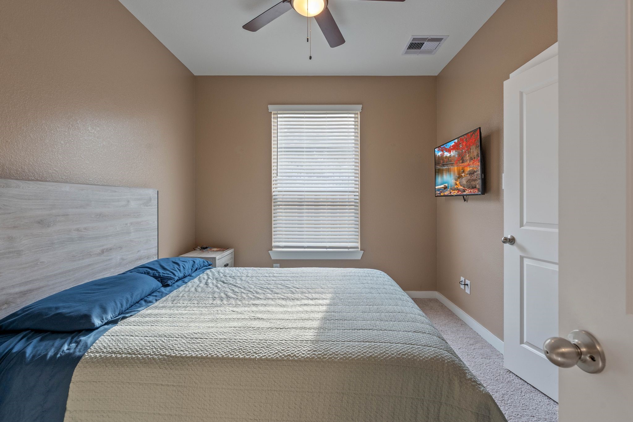509 Timber Voyage Court Conroe, TX 77304 - Photo 26 of 36 a bedroom with a bed and a chandelier