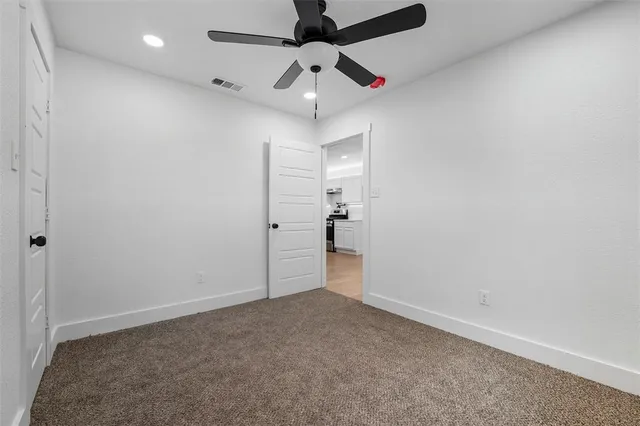 en empty room with ceiling fan and window