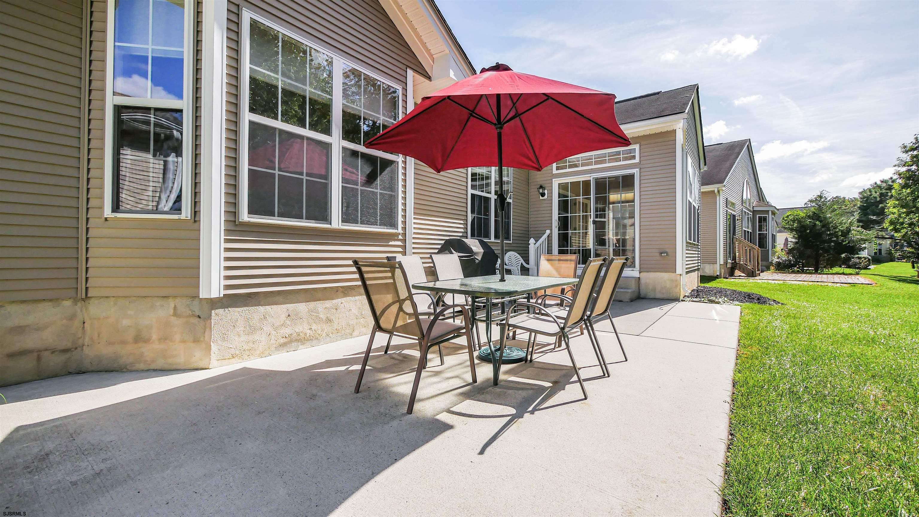 33 Brampton Street Smithville, NJ 08205 - Photo 34 of 37 a patio with a table and chairs under an umbrella