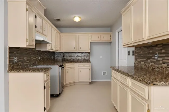a kitchen with granite countertop white cabinets and white appliances