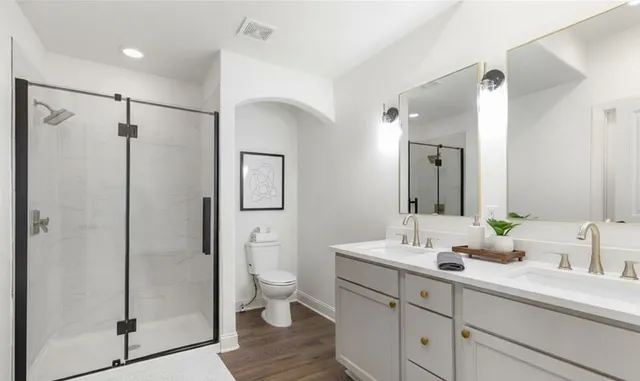 a bathroom with a double vanity sink mirror and toilet