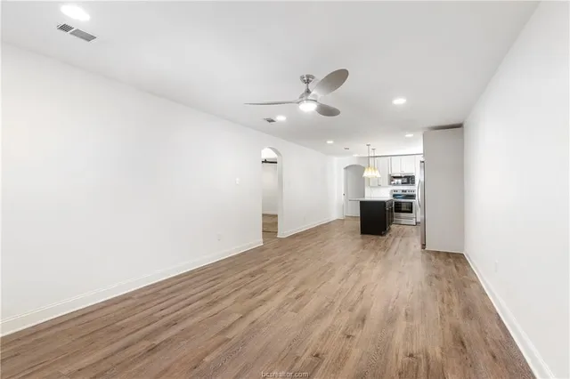a view of empty room with wooden floor