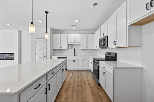 a kitchen with white cabinets stainless steel appliances and a sink