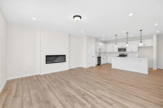 a view of kitchen with kitchen island white cabinets and refrigerator