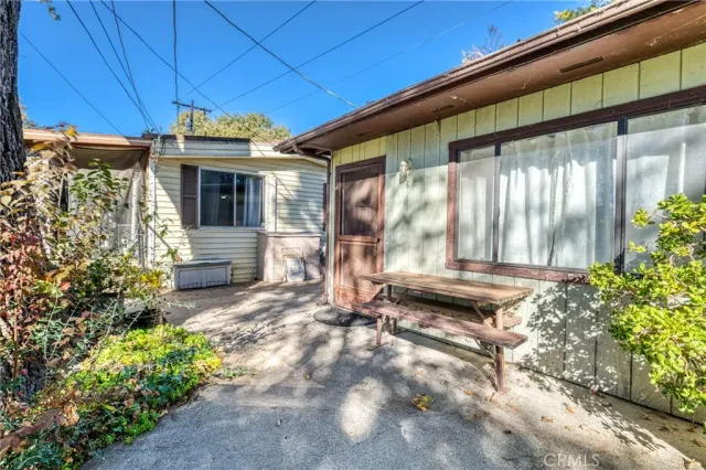 a view of a porch with a table and chairs under an umbrella