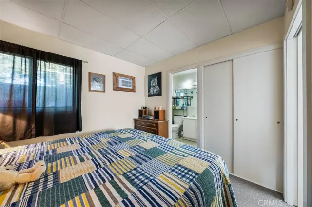 a bedroom with a bed and a dresser next to a window