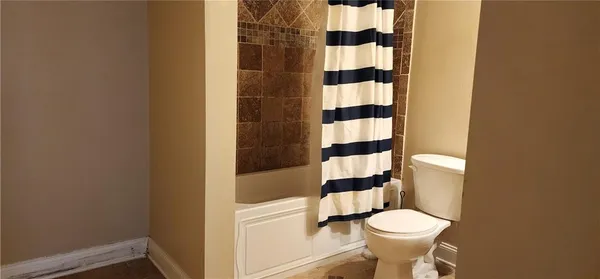 a white toilet sitting next to a shower curtain
