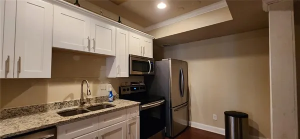 a kitchen with stainless steel appliances granite countertop a refrigerator and a stove
