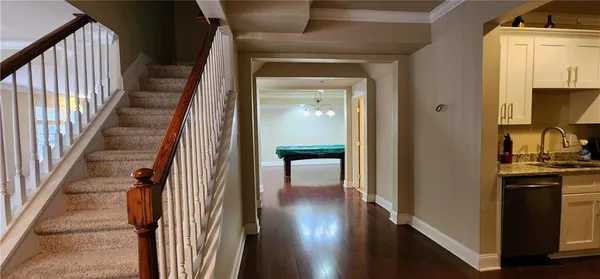 a view of a hallway with wooden floor and staircase