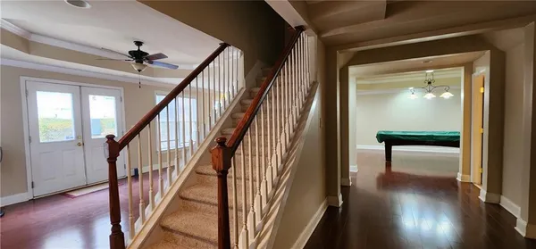 a view of a hallway with wooden floor and staircase