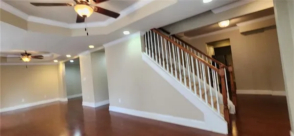 a view of a hallway with wooden floor and staircase