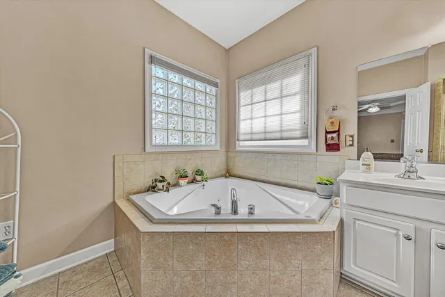 a bathroom with a tub sink and mirror