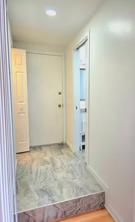 an empty room with wooden floor and a bathroom